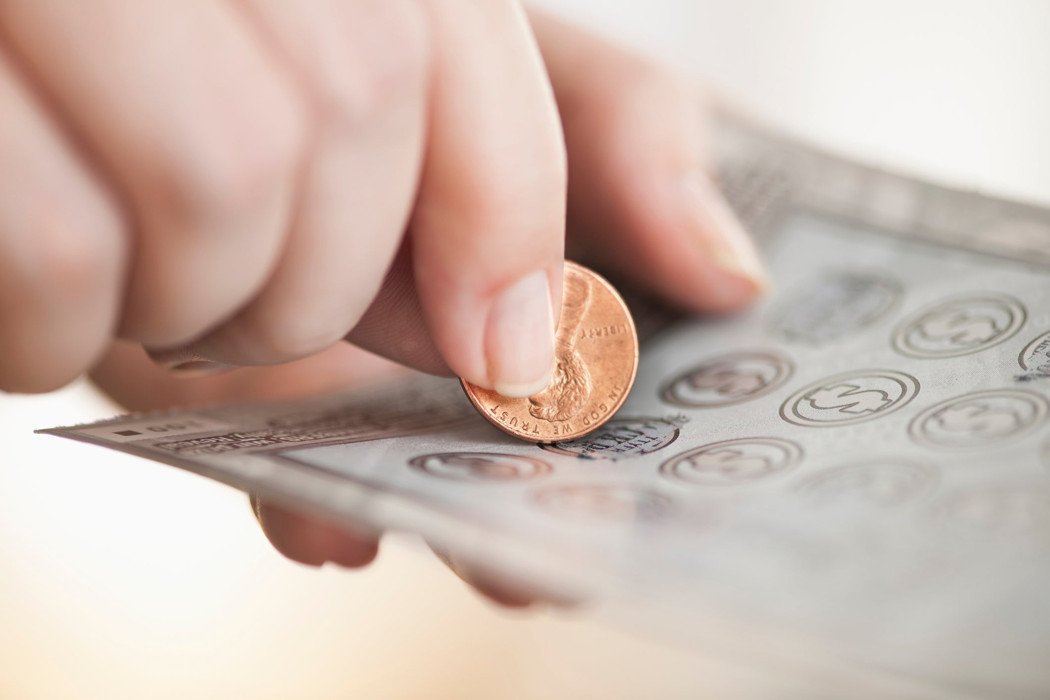 Hand using a penny for a scratch off