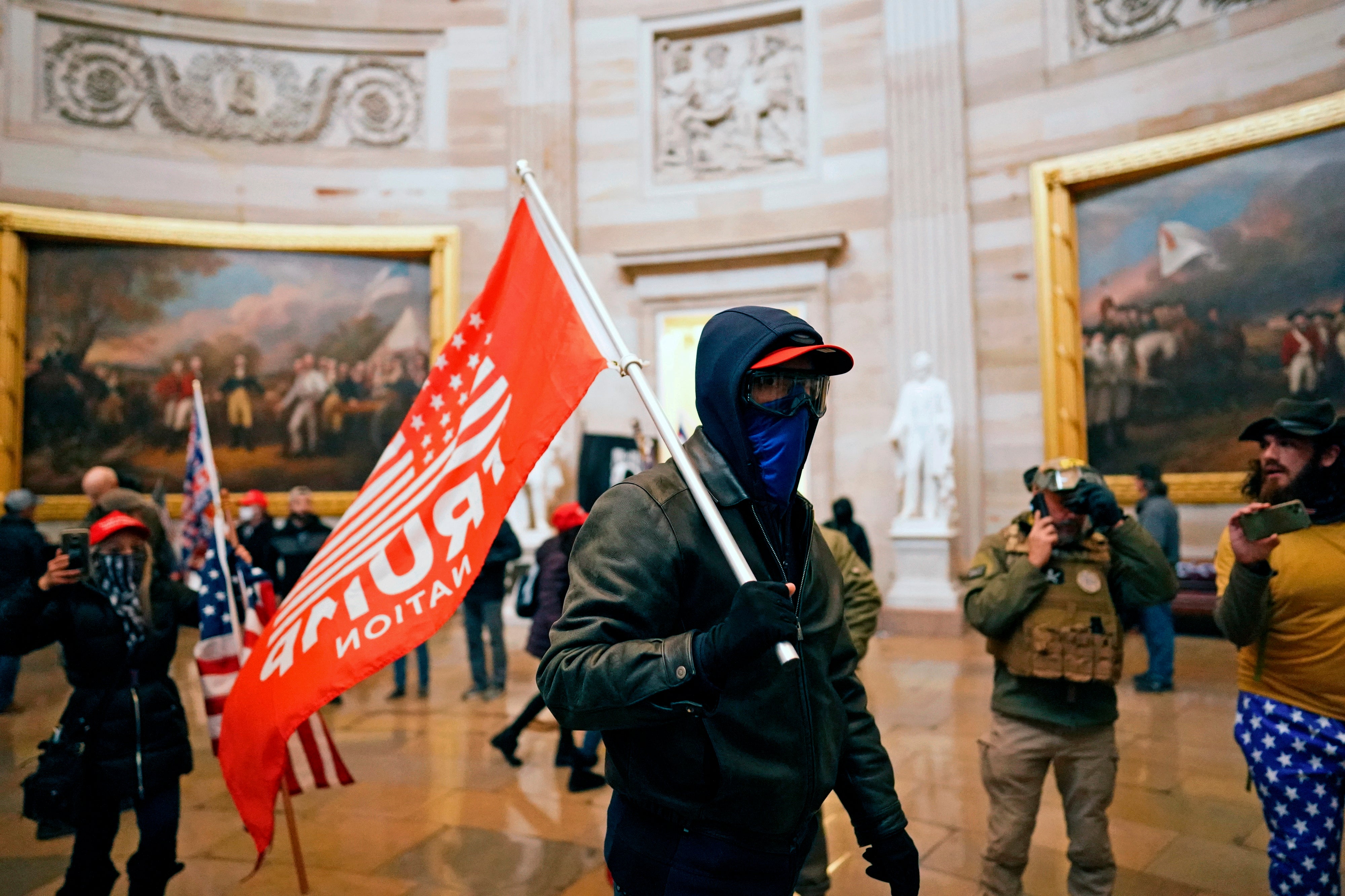 A rioter waves a "Trump Nation" flag inside the Capitol on Jan. 6, 2021.