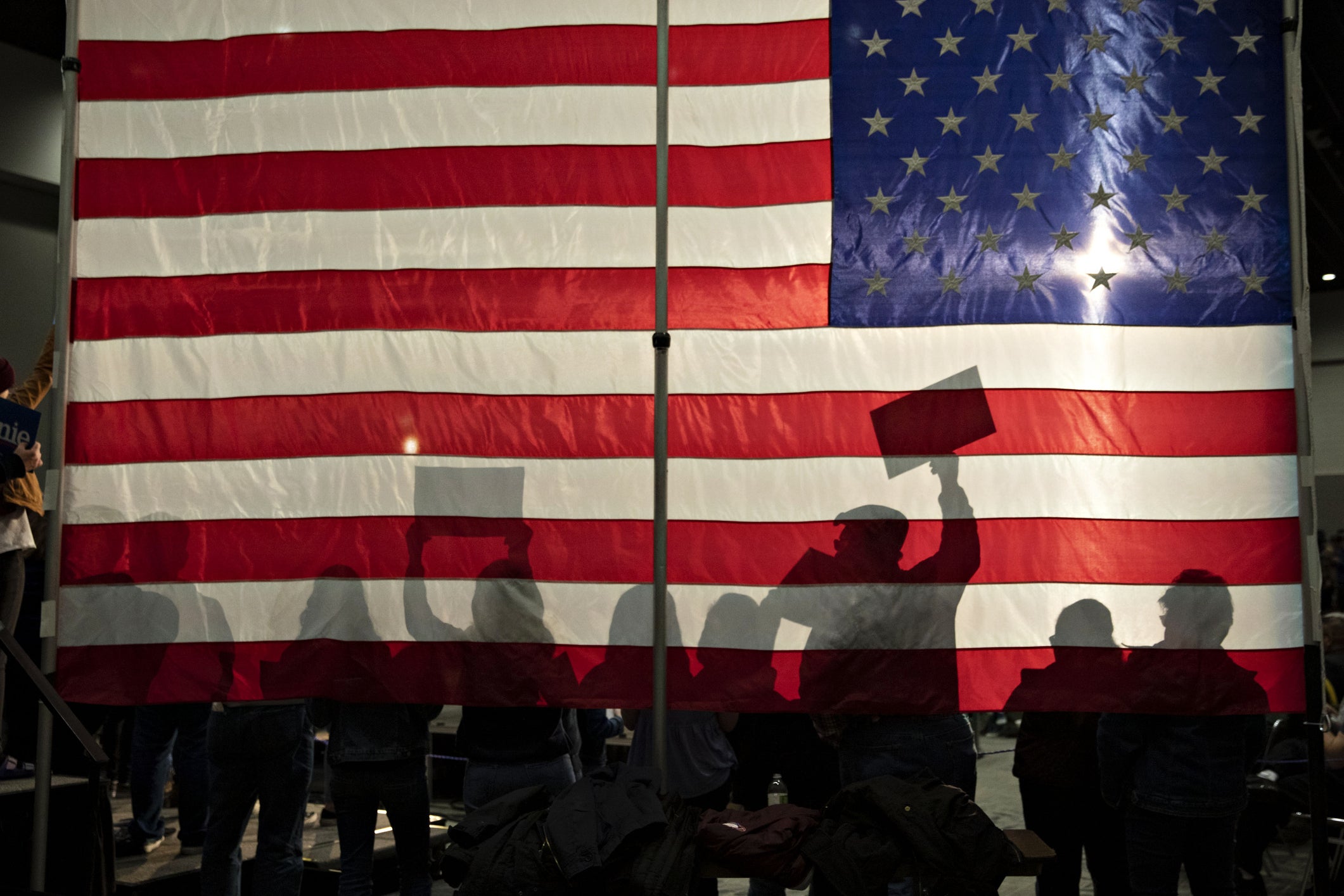 American flag background with silohuettes of people 