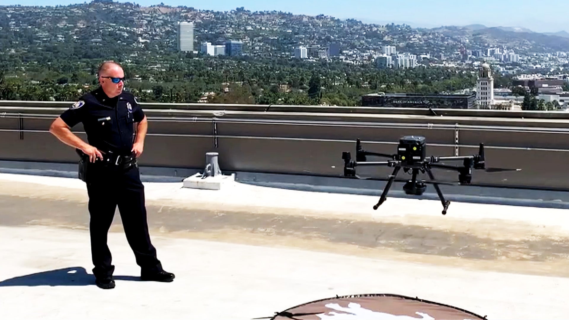 A Beverly Hills police officer stands next to a police drone