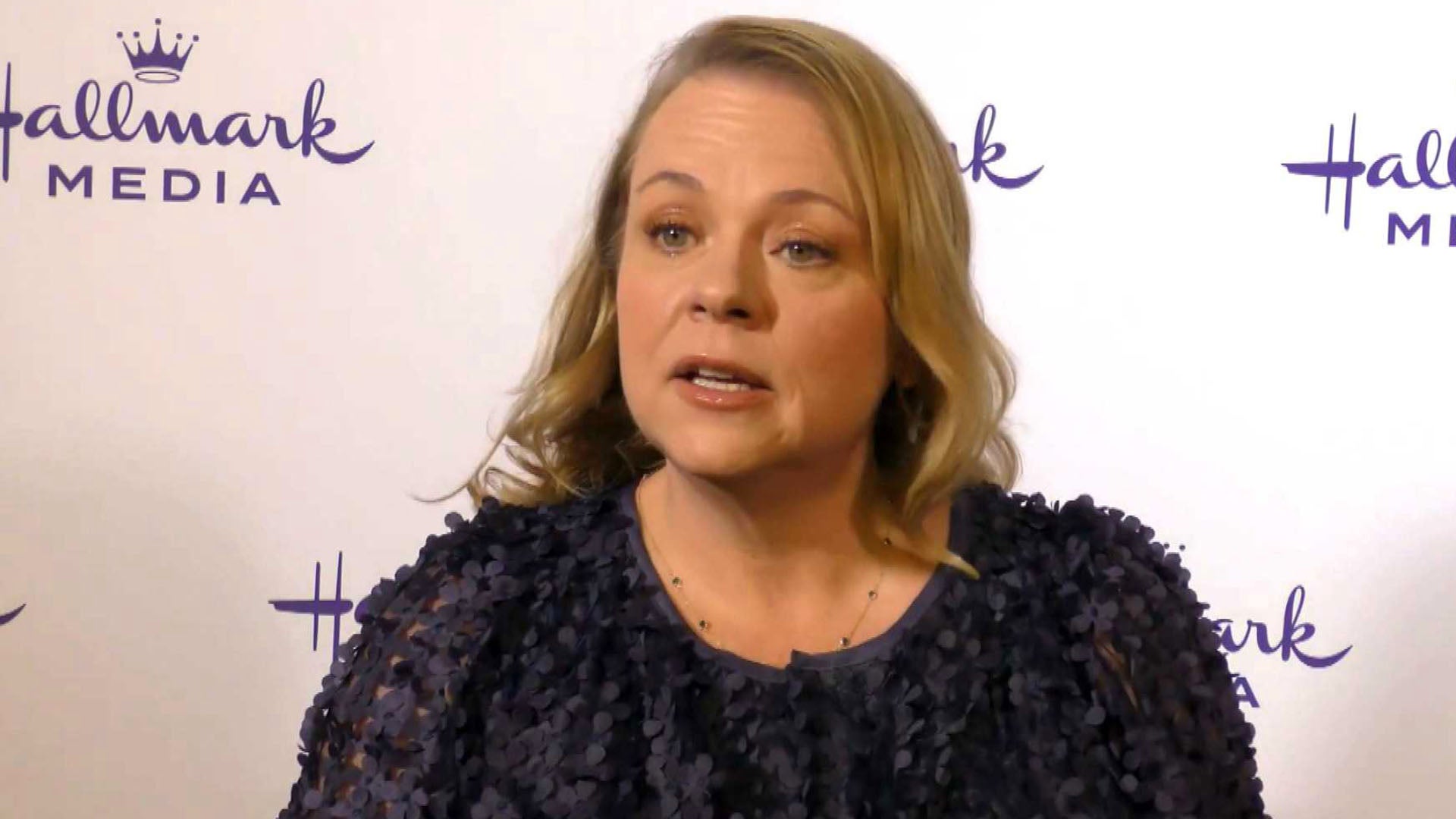 Lisa Hamilton Daly standing in front of a Hallmark step and repeat