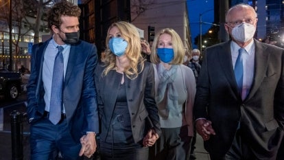 Elizabeth Holmes and others wearing masks outside