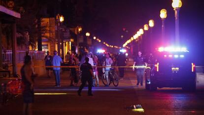 Bystanders and Hollywood Police officers are seen nearby the shooting scene after an altercation ended in gunfire at Hollywood Beach Broadwalk in Hollywood, Florida