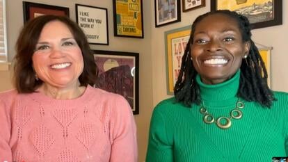 Two women smiling into camera.