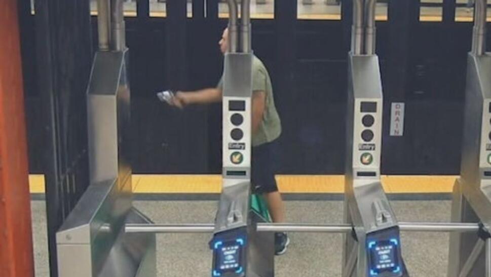 John Rote holding up gun in subway station