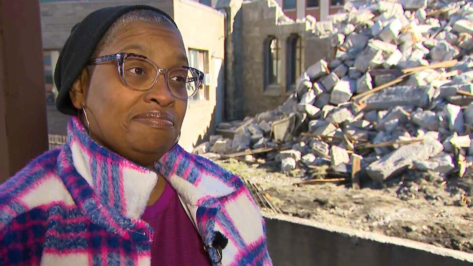 Teresa Tymes with rubble from church collapse in background
