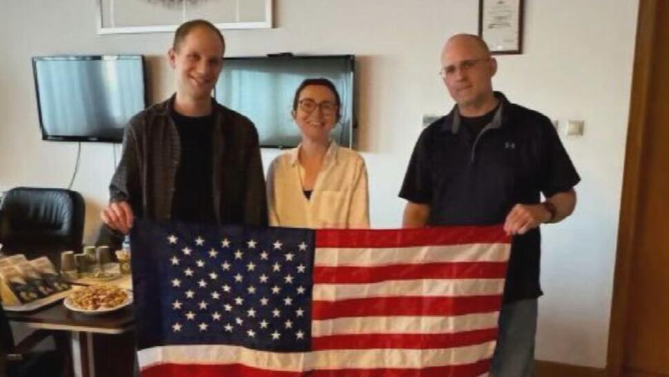 Evan Gershkovich, Alsu Kurmasheva and Paul Whelan holding United States flag